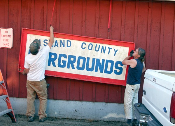 Timothy Hull and another volunteer put up the old fair sign which