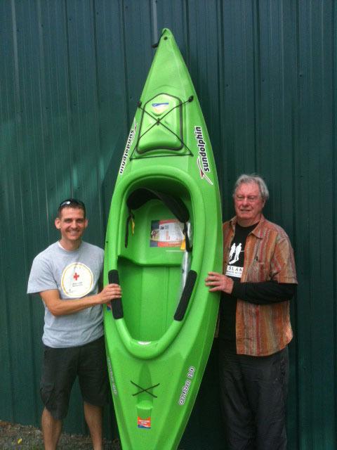 Anton Kleparek holds the donated kayak won by his cousin Wade Longman of Utah next to Mike Mcvay