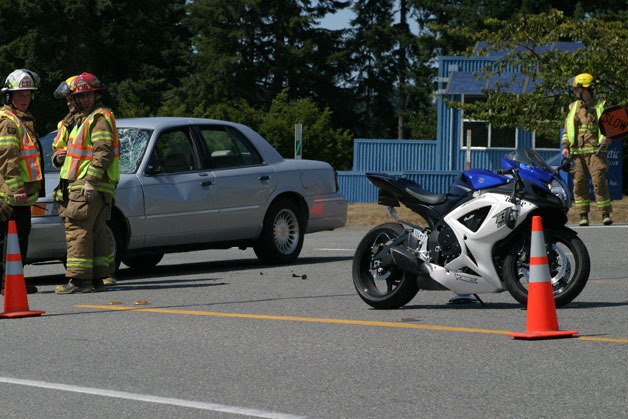 South Whidbey Fire/EMS firefighters and emergency medical technicians inspect the scene of a car vs. motorcycle crash in Freeland on Tuesday afternoon. The motorcyclist was airlifted to Harborview Medical Center.