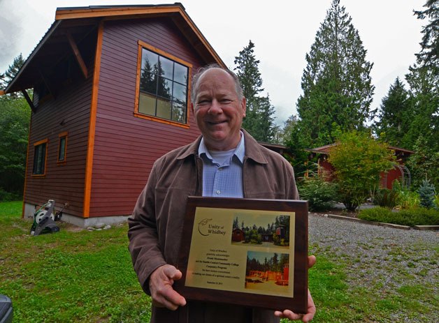 Freeland resident Frank Mestemacher holds up a plaque recognizing six years of volunteer efforts to build Unity of Whidbey’s new church.