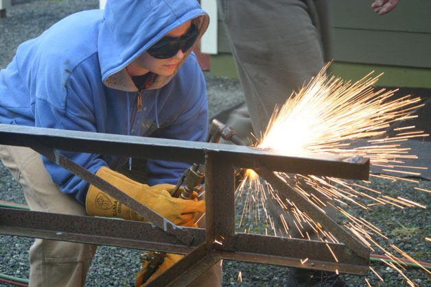 Celina Dill works on welding improvements to the chassis on which her tiny house will sit.