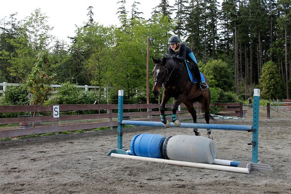 Young show rider Vienna Canright practices show jumping at Harmony Hill Stables under the tutelage of owner and trainer Sarah Moulton.