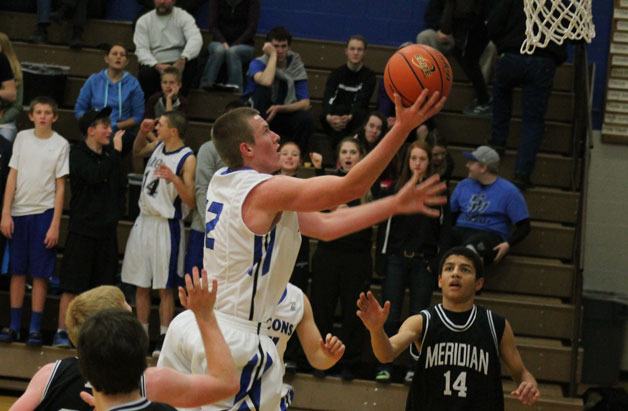 Falcon junior forward Parker Collins rises to the hoop for a layup against Meridian on Wednesday