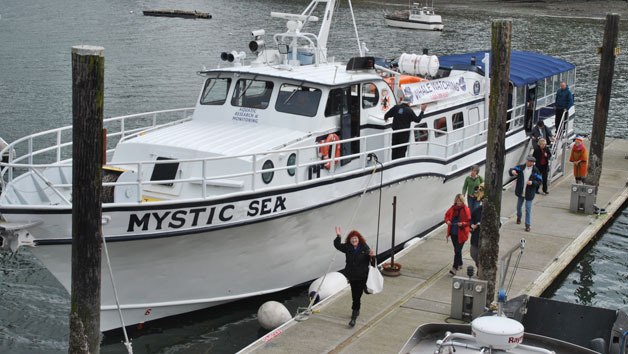 Whale-watching tourists disembark from the Mystic Sea at the Port of South Whidbey Harbor at Langley. The owners of the Mystic Sea donated a two-hour evening cruise as a fundraiser for the Langley Whale Center.