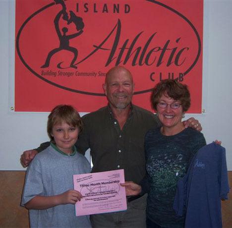 JaNoah Spratt stands with Steve Shapiro and Debora Valis of Island Athletic Club as he accepts a donation valued at $345 for the Good Cheer Talent Show raffle. It’s just one of the many prizes collected by the youngster for the fundraiser.