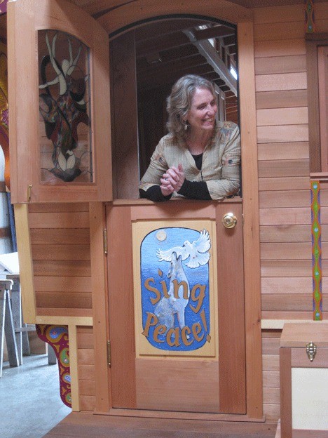 Pushkara Sally Ashford peeks out the door of her brand new handcrafted gypsy vardo wagon. Ashford is getting ready to wheel out from Whidbey on a pilgrimage for peace.