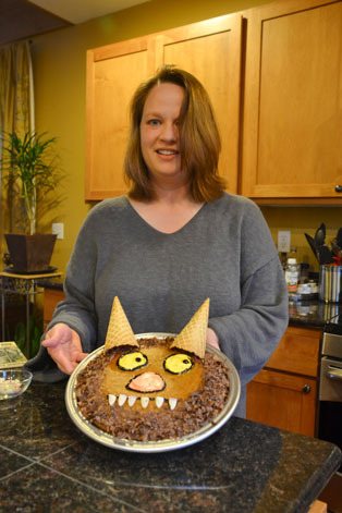 Jill Yomnick displays her edible book inspired by the book “Where the Wild Things Are.” The edible book is a homemade apple spice cake.