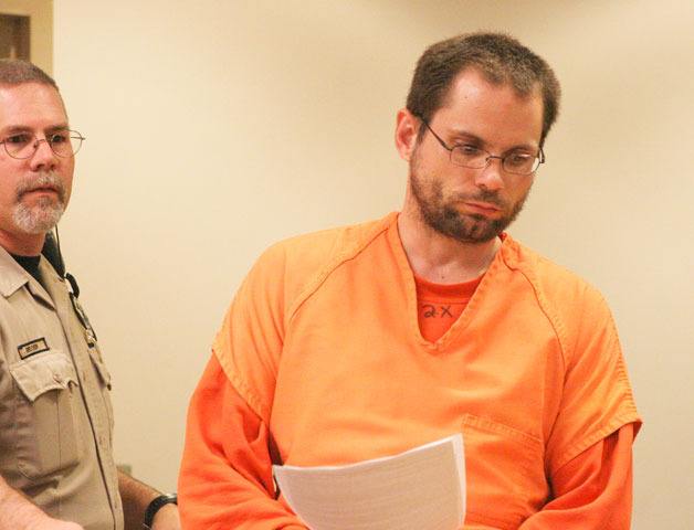 Sean DeMerchant enters a courtroom Tuesday in his first appearance since his arrest for allegedly stabbing his parents in their home near Freeland Sunday.