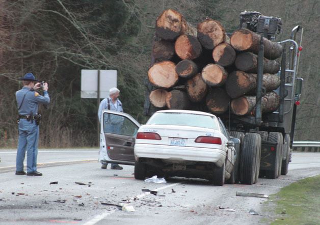A trooper with the Washington State Patrol takes a photograph of a truck-and-vehicle crash that closed Highway 525 Wednesday.
