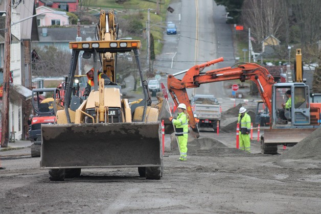 Workers clear dirt and grade the road near the post office and Langley City Hall on Second Street on Monday