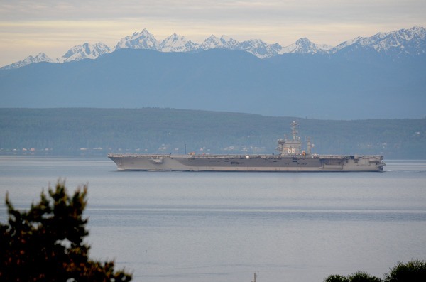 The USS Nimitz cruises by Bush Point around 6:30 a.m. Monday
