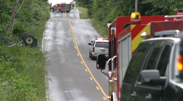 Emergency workers block Humphrey Road because a cement truck rolled over into a ditch and fractured a power pole the morning of June 26.