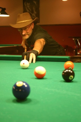 Mike Dolan lines up a shot at Houdini’s Billiards in Freeland. The sour economy has forced him out of business.