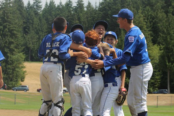 South Whidbey’s 11/12 Little League All-Stars hug Aidan Donnelly he made the winning catch in the outfield to beat Anacortes