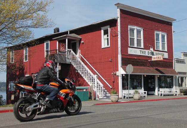 A motorcyclist cruises past the Dog House Tavern on May 1. The historic building’s owner says he plans to tear it down after land use requests regarding renovation fell through.
