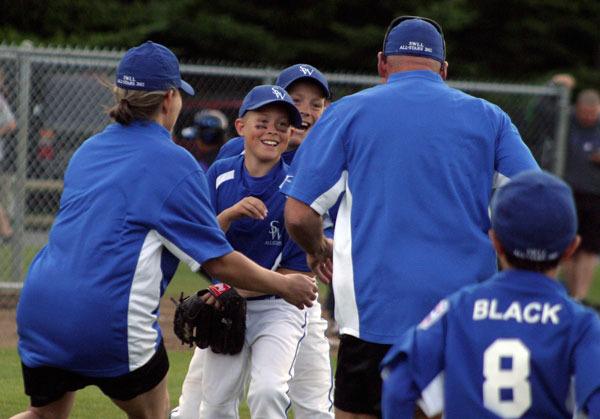The South Whidbey team swarms pitcher Drew Fry after he fanned the final two North Whidbey batters. Behind Drew is first baseman Carlson Filla