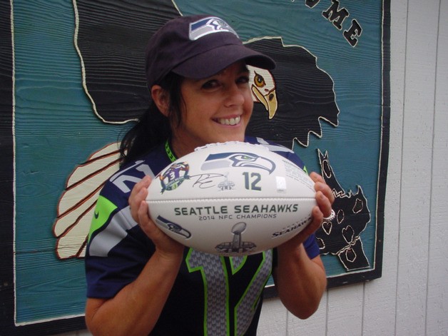 Kyrsti Synchak holds her prize: a football signed by Seattle Seahawks quarterback Russell Wilson.