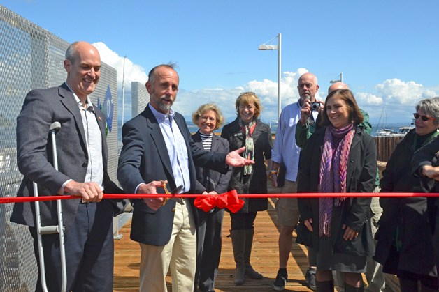 Port of South Whidbey Commissioner Curt Gordon performs the honors during a ribbon-cutting ceremony at South Whidbey Harbor on Friday