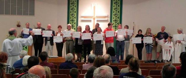 Members of Trinity Lutheran Church in Freeland hold up symbolic checks representing the $20