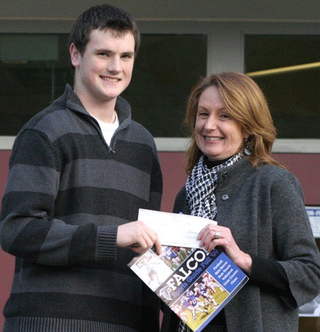 Student president Tyler “Chuck” Norris accepts a check for $600 from South Whidbey Record publisher Marcia VanDyke.
