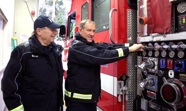 Charlie Bieber and Clinton station Lieutenant Gary Guernsey demonstrate the fire engine’s capabilities. The rig is one of South Whidbey Fire/EMS’s newest