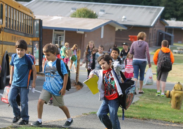 Children file off a bus and into the halls of South Whidbey Elementary School on Monday
