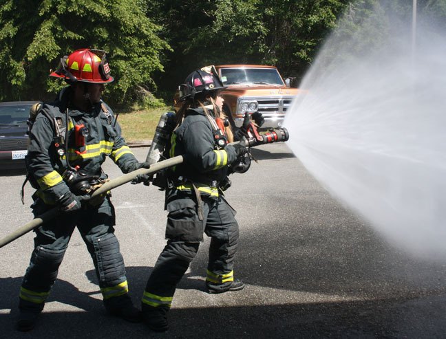 Central Whidbey Fire & Rescue volunteers Alex Majestic and Holly Slothower work a firehose in a demonstration at the district’s Race Road station. The district is hunting for new volunteers.