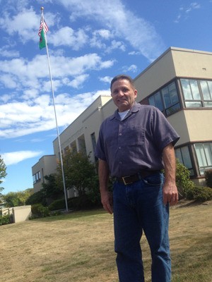 Island County Facilities Director Larry Van Horn stands before a memorial flag pole he had reconditioned at the county’s Coupeville campus.
