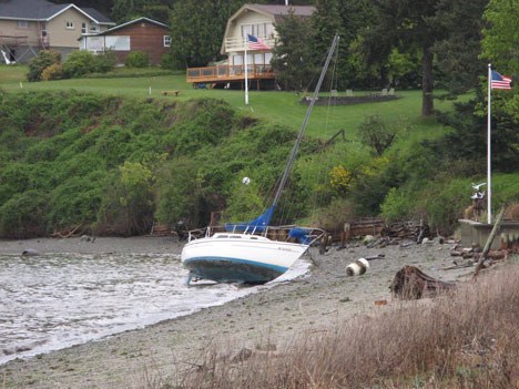 A 27-foot sailboat rests on a Holmes Harbor beach near Freeland Park Tuesday after breaking free from its mooring and drifting about 100 yards.