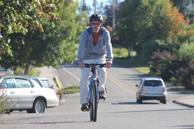Michael Patterson of Clinton rides his bike through downtown Langley on Monday. Residents expressed their ire over the city’s transportation improvement plan due to a lack of cyclist focus.