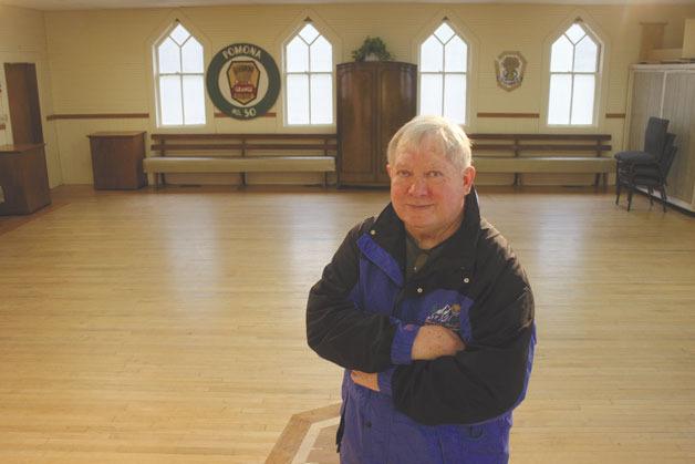 Chuck Prochaska stands on the maple floor of the Deer Lagoon Grange — made from salvaged wood from Fort Casey — in the historic building’s signature hall. Prochaska is leading an effort to raise funds to pay for needed repairs at the iconic South Whidbey gathering place.