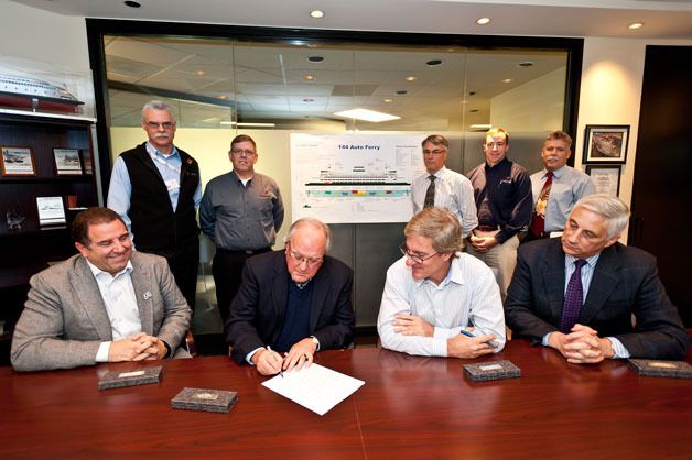 Shipyard and state ferry officials sign a contract change order with Vigor Industrial and its US Fab shipbuilding division to begin construction of a new 144-car ferry at Washington State Ferries headquarters in Seattle on Tuesday. From left