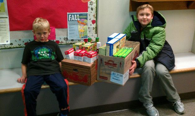 Nolan and Brennan Pearson bring in their first load of non-perishable food for the South Whidbey Elementary School food drive.