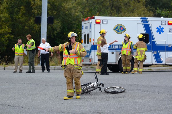 South Whidbey Fire/EMS firefighter Jon Gabelein directs traffic Thursday morning in the intersection of Highway 525 and Fish Road following a bicycle versus van accident.