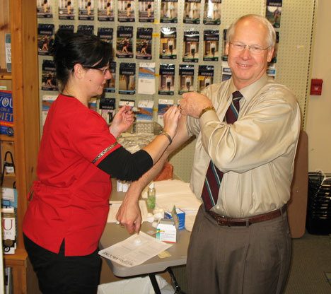 Grin and bare it: South Whidbey School Superintendent Fred McCarthy sets an example for public school children by getting his swine flu shot at Linds Pharmacy in Freeland on Tuesday.