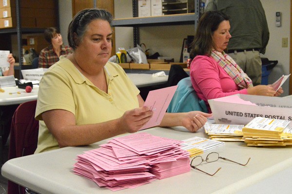 Rachel McDougald and Toni Craggs open and sort ballots turned into the Island County Auditor’s office.