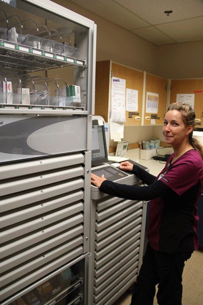 Whidbey General Hospital pharmacy technician Cherie Post dispenses medication from a new automated machine from Omnicell. Post is the “administrative user” and attended training sessions before teaching other hospital staff how to use this new technology.