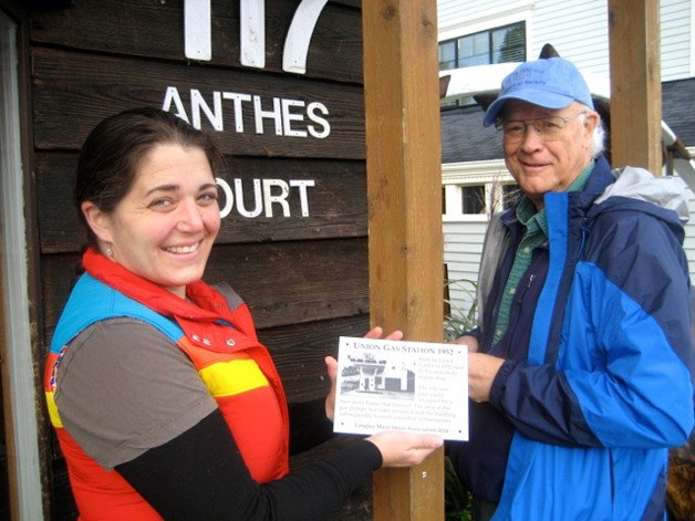 Sarah Boin and Bob Waterman install the first history plaques at The Langley Whale Center. The plaques will give a brief history of the origin of the building and an image of the earliest structure.