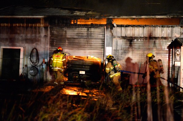 South Whidbey Fire/EMS firefighters rush to quell flames at a South Whidbey home Monday. The fire caused an estimated $100