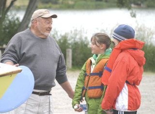 South Whidbey Yacht Club commodore Don McArthur explains the finer points of a 12-foot Pelican sailboat to Ellie Andersen (center) and Abby Hodson on Wednesday at Lone Lake.