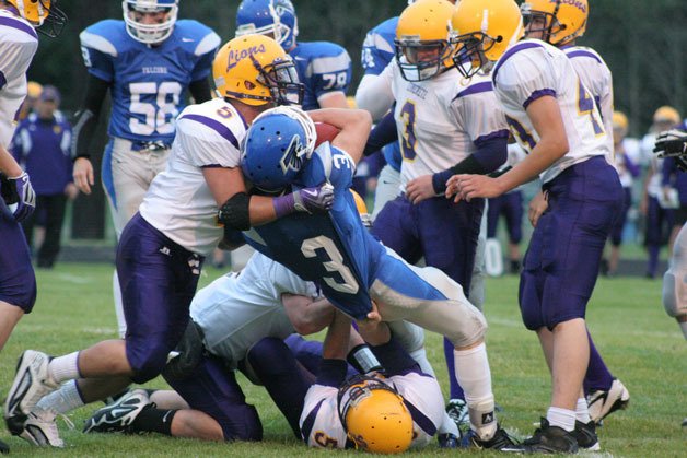 A trio of Lions defenders tries to pull down Falcon running back Sam Lee during South Whidbey’s 36-6 win in the non-conference match-up.
