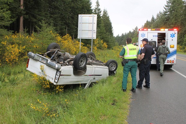 Emergency responders examine the scene of a one-vehicle accident Tuesday afternoon. The driver was taken to Whidbey General Hospital though it is unclear whether she sustained injuries or was taken as a precautionary measure.