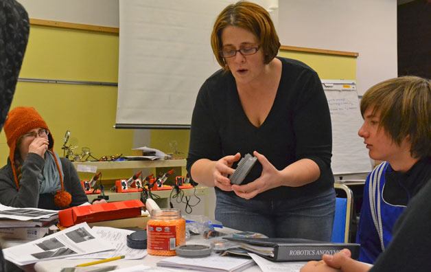 Mentor Timmie Sinclair explains a concept with the propulsion system to team members Grace Lee and Peter Moore
