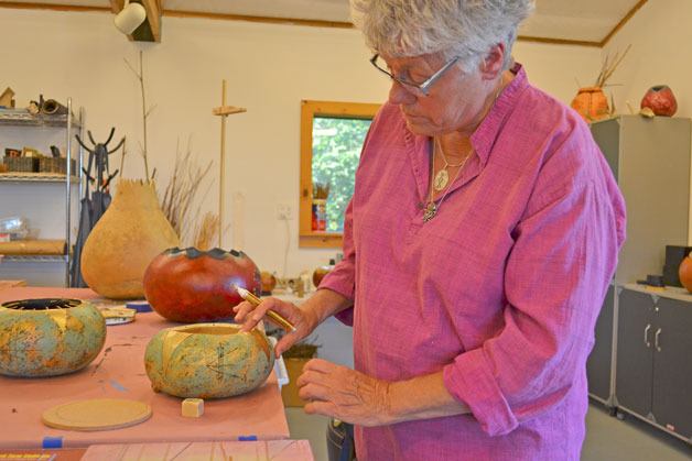 Susanne Newbold adds the finishing touches to her gourd. Newbold teaches gourd decorating classes at Sweetwater Creek Farm Studio.