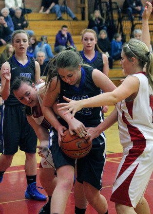 Falcon junior Abby Hodson fights for a rebound against Coupeville seniors Hailey Hammer and Bree Messner in the Cascade Conference rivalry game Tuesday at Coupeville High School. Behind them are Morgan Davis