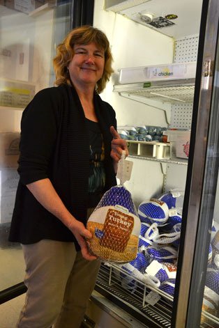 Karen Korbelik holds up one of the many turkeys offered at Good Cheer. The food bank has about 250 turkeys to last through Christmas. Korbelik is hoping for more donations throughout the month.