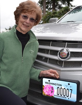 Clinton artist Barbara Cornelson displays the new license plate she designed that will help raise money for Meerkerk Gardens.