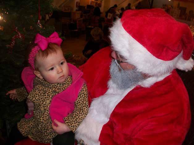 Annabelle Bulle of Clinton listens attentively as Santa speaks with her about what she might want for Christmas. Dave Neil spent a couple of hours away from his Island Apiaries booth