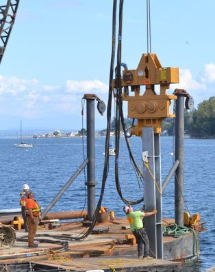 Workers pound new piles into South Whidbey Harbor Wednesday.