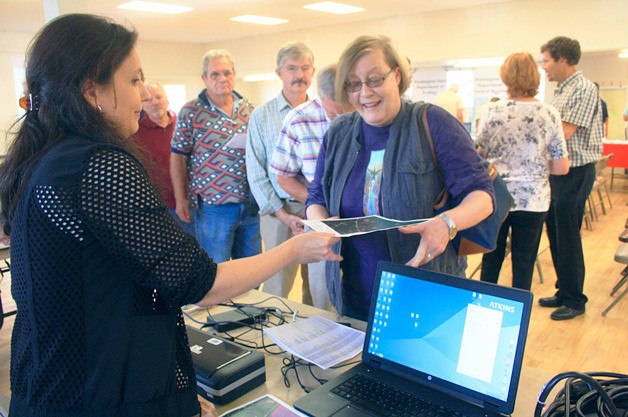 A FEMA worker hands a shoreline resident a customized map of her waterfront property